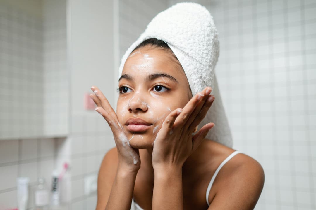 Close-up of a person washing their face with a gentle cleanser